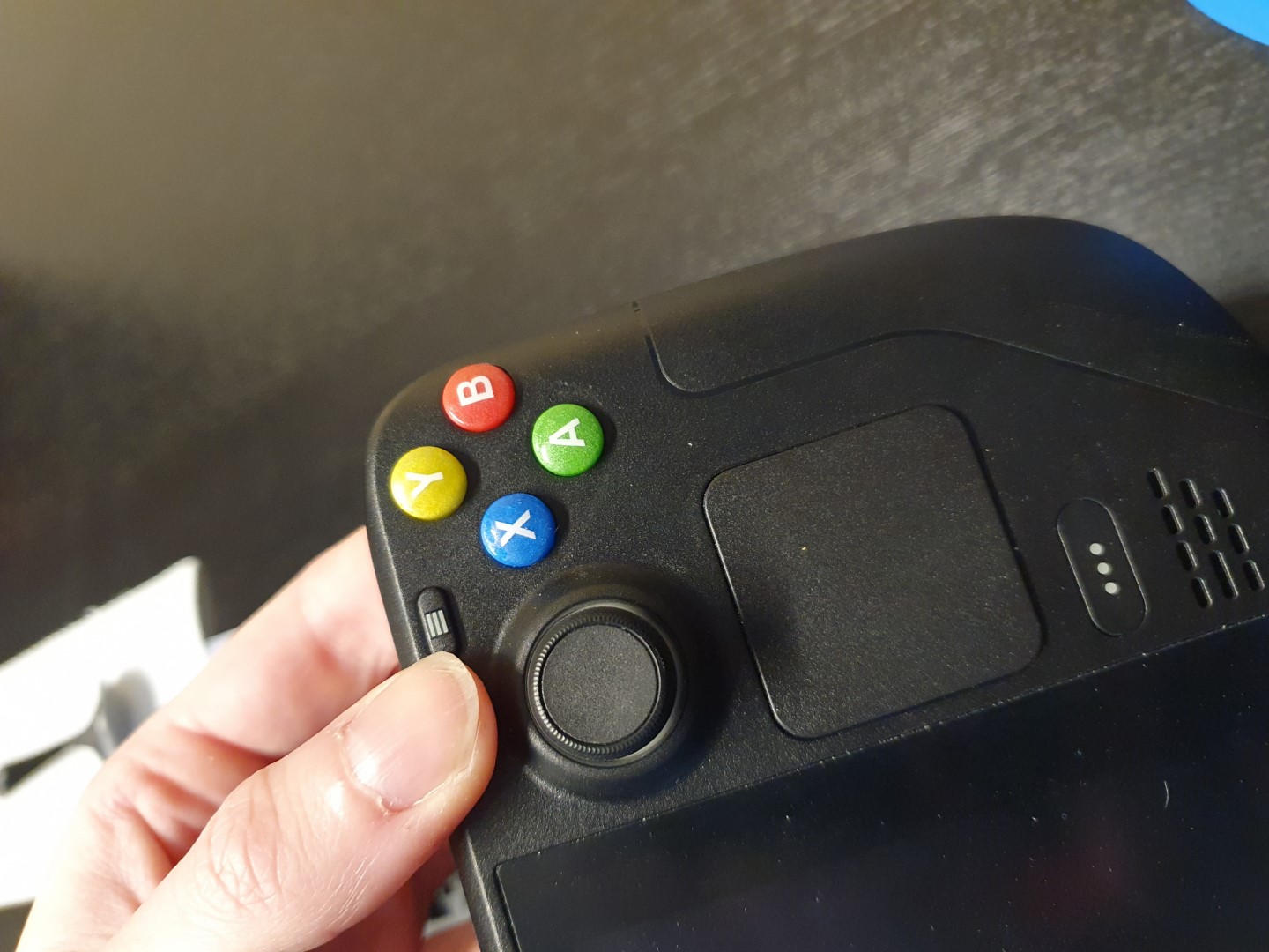 Colorful custom action buttons on the right side of a SteamDeck held up to the camera.
