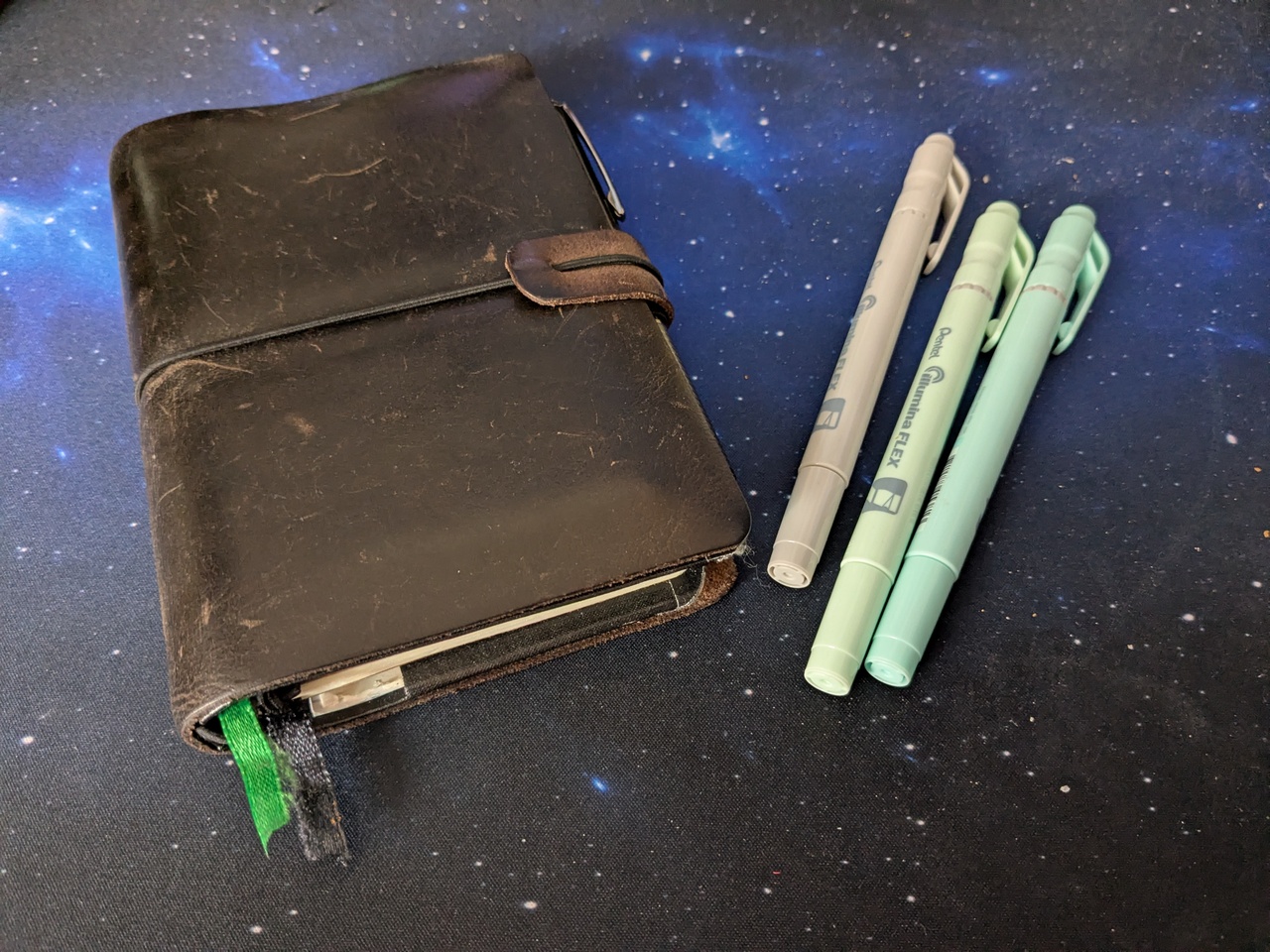 My closed journal on my desk, next to it a couple of pastelle colored marker pens.